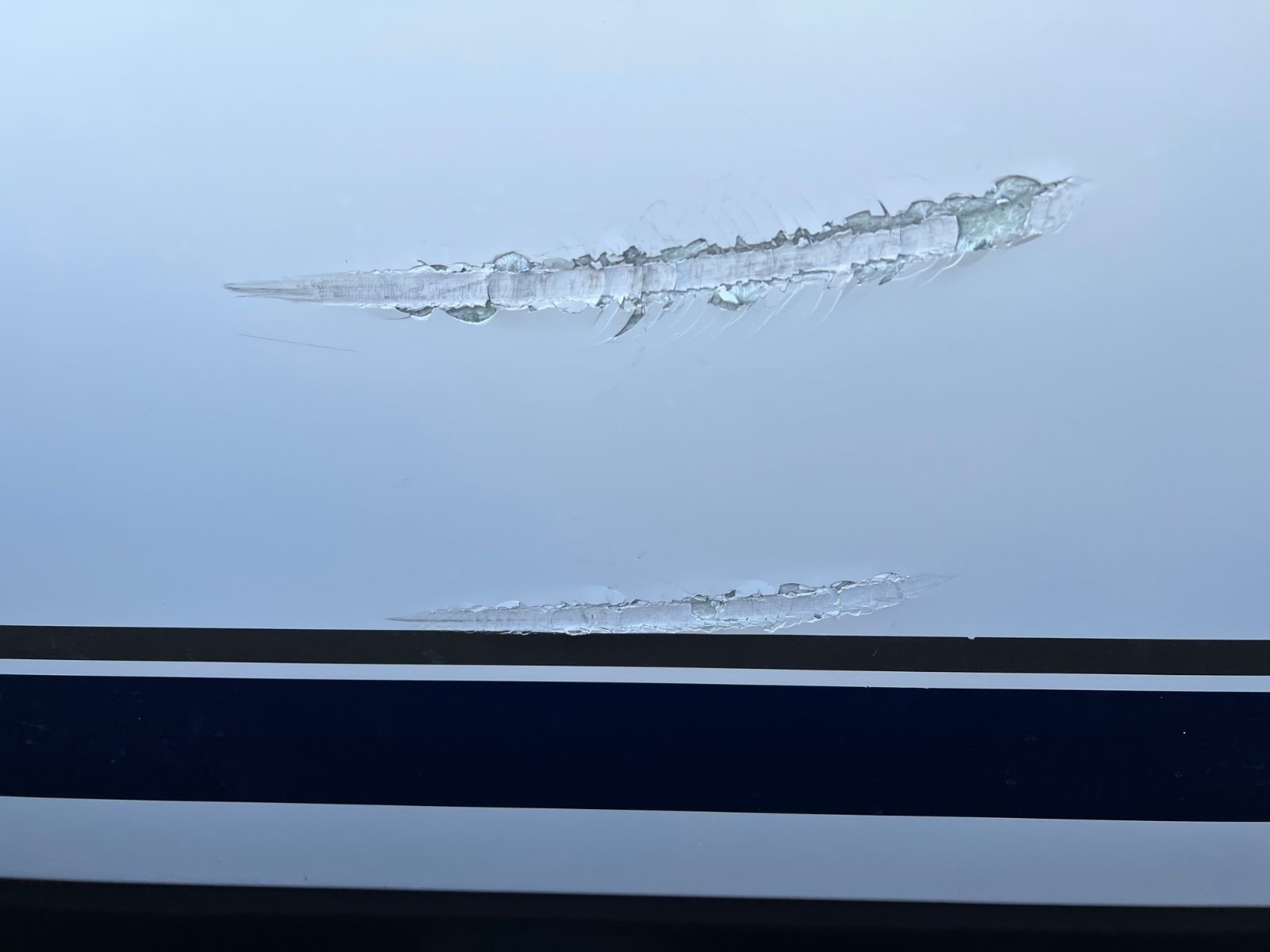 Typischer Anlegeschaden mit beschädigtem Gelcoat an einer Yacht